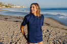 Woman on a beach wearing a Floatee anti-drowning T-shirt for adults, color blue with short sleeves