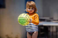 little girl is wearing a yellow anti-drowning tee-shirt and playing with a ball